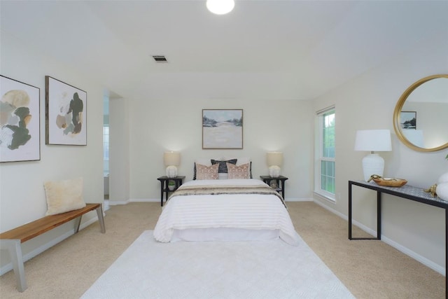 bedroom featuring baseboards, light carpet, and visible vents