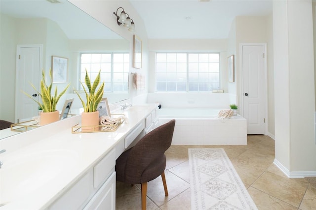 full bathroom featuring a sink, a garden tub, double vanity, and a wealth of natural light