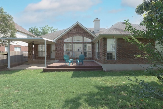 back of house with fence, a chimney, a yard, and brick siding