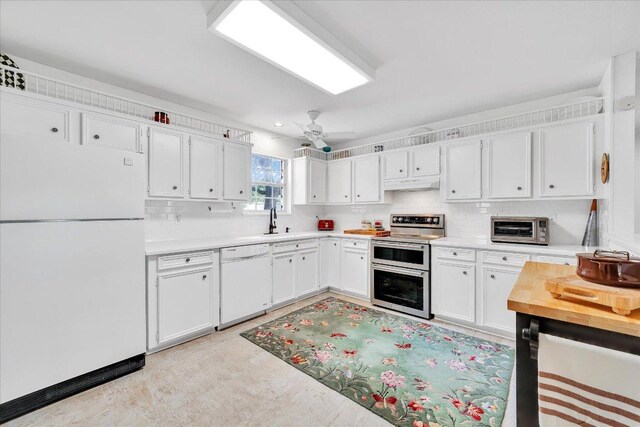 kitchen featuring light countertops, under cabinet range hood, white appliances, and a toaster