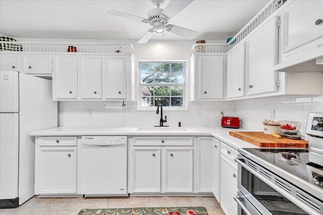 kitchen featuring white appliances, white cabinetry, a sink, and tasteful backsplash