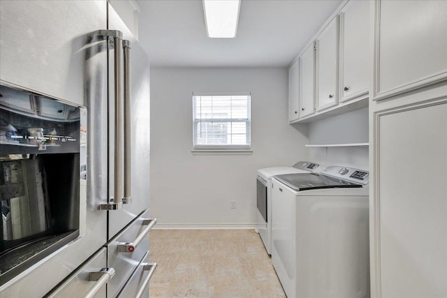 clothes washing area featuring baseboards, light wood-type flooring, cabinet space, and washing machine and clothes dryer