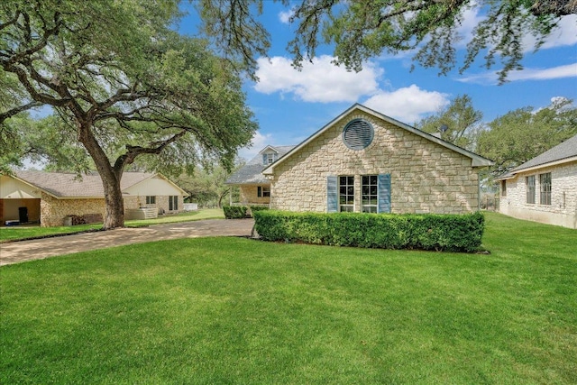 view of side of property featuring a lawn and stone siding