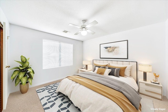 bedroom with visible vents, baseboards, a textured ceiling, a ceiling fan, and carpet