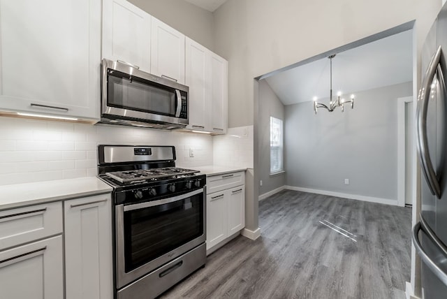 10429 Firethorn Ln, Austin, TX 78750 - kitchen with backsplash, stainless steel appliances, white cabinets, and a notable chandelier