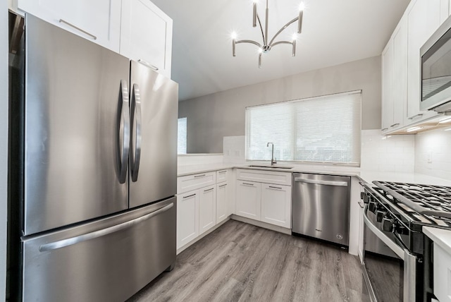 10429 Firethorn Ln, Austin, TX 78750 - kitchen featuring light wood-type flooring, a sink, appliances with stainless steel finishes, and light countertops