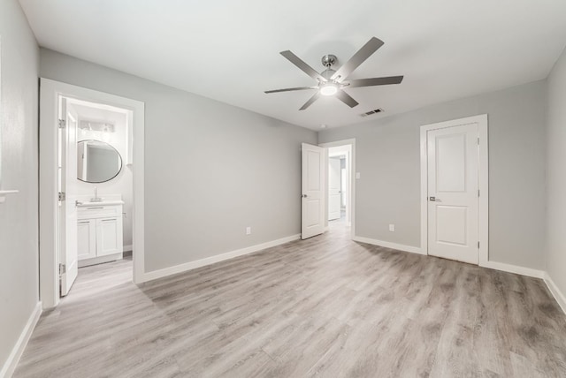10429 Firethorn Ln, Austin, TX 78750 - unfurnished bedroom featuring a sink, light wood-style flooring, baseboards, ensuite bathroom, and visible vents