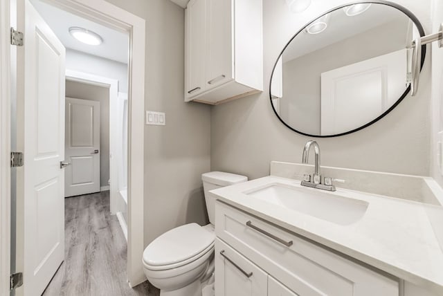 10429 Firethorn Ln, Austin, TX 78750 - bathroom with a washtub, walk in shower, wood finished floors, vanity, and toilet