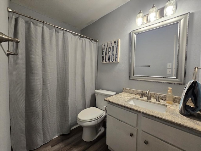 full bathroom featuring toilet, wood finished floors, and vanity