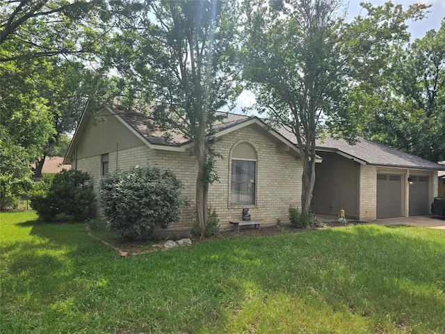 ranch-style house featuring a garage, concrete driveway, a front yard, and brick siding