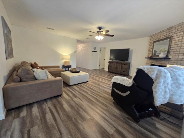living area with visible vents, a ceiling fan, baseboards, and wood finished floors