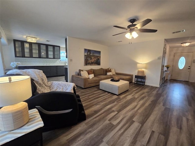 living room featuring baseboards, visible vents, ceiling fan, and dark wood-type flooring