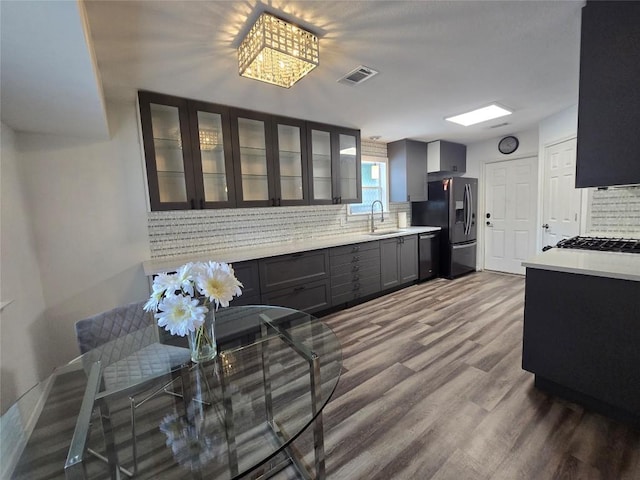 kitchen with visible vents, light countertops, a sink, backsplash, and stainless steel appliances