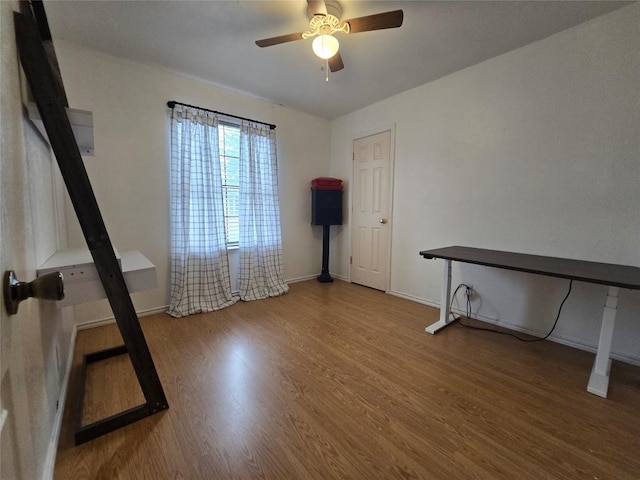 interior space featuring baseboards, ceiling fan, and wood finished floors