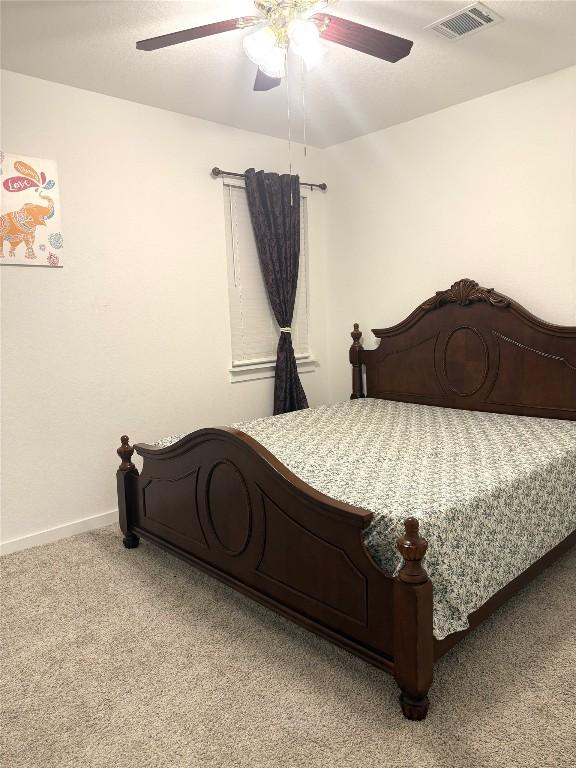 bedroom featuring light colored carpet, baseboards, visible vents, and ceiling fan