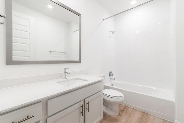 full bathroom with shower / bathtub combination, toilet, wood finished floors, and vanity
