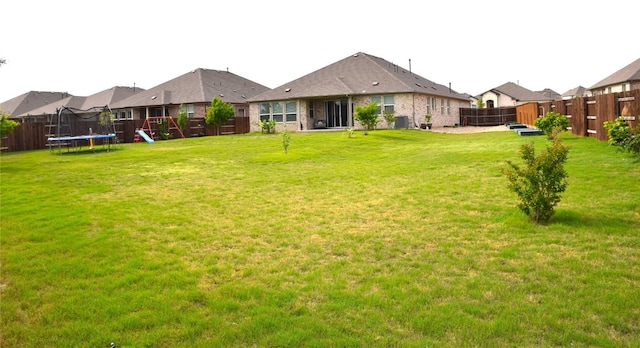 view of yard with a fenced backyard and a trampoline