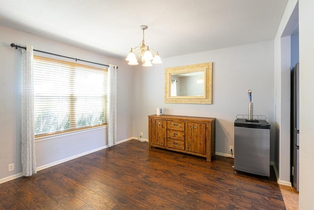 dining space with baseboards, dark wood finished floors, and a notable chandelier