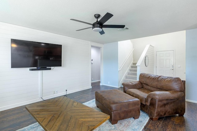 living room with stairway, baseboards, wood finished floors, and visible vents
