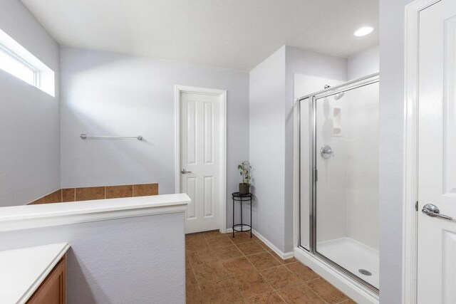 bathroom with vanity, baseboards, and a stall shower