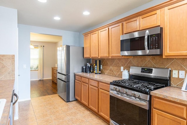 kitchen with recessed lighting, light countertops, decorative backsplash, and stainless steel appliances
