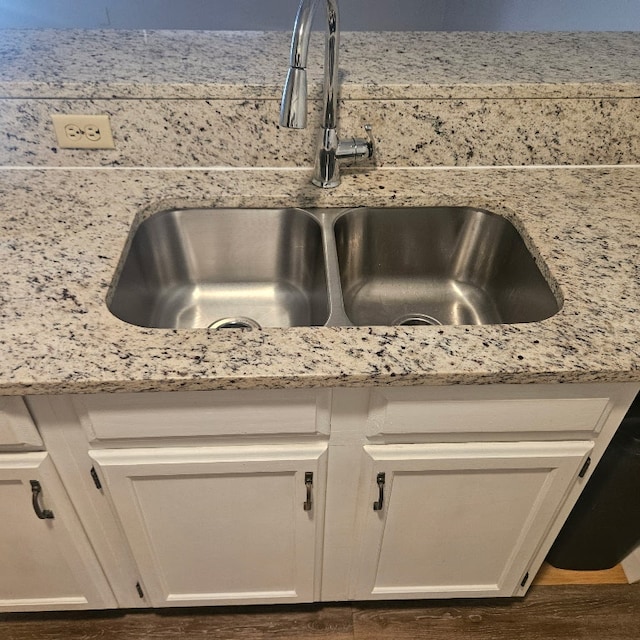 3012 Whisper Oaks Ln Unit I, Georgetown, TX 78628 - kitchen view of a sink, white cabinets, light stone counters, and wood finished floors
