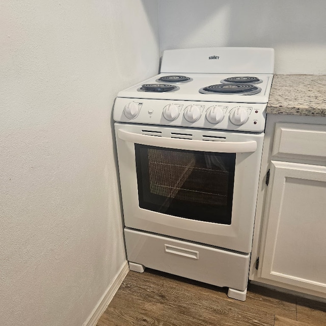 3012 Whisper Oaks Ln Unit I, Georgetown, TX 78628 - kitchen view of white electric range oven, dark wood-style flooring, and baseboards