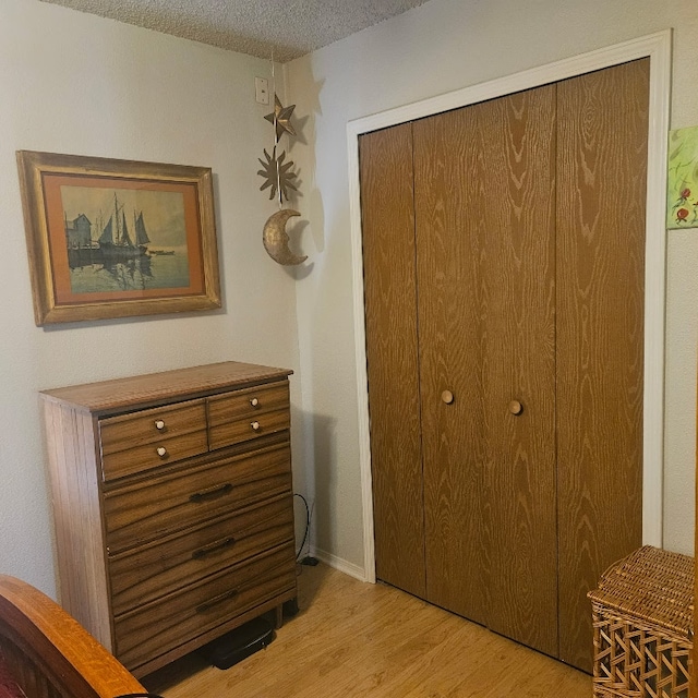 3012 Whisper Oaks Ln Unit I, Georgetown, TX 78628 - bedroom with light wood-style floors, a textured ceiling, and a closet