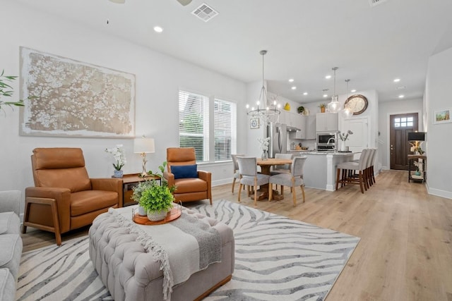 144 Monterey Oak Trl, Georgetown, TX 78628 - living area featuring visible vents, baseboards, light wood-style floors, recessed lighting, and a notable chandelier