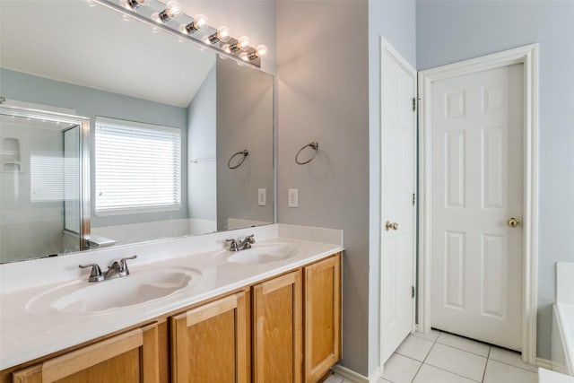 bathroom featuring a tub to relax in, a sink, tile patterned floors, and double vanity