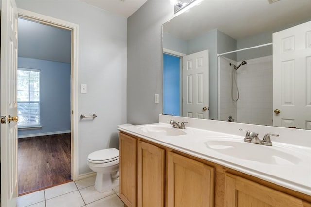 bathroom featuring a sink, tile patterned flooring, toilet, and a shower