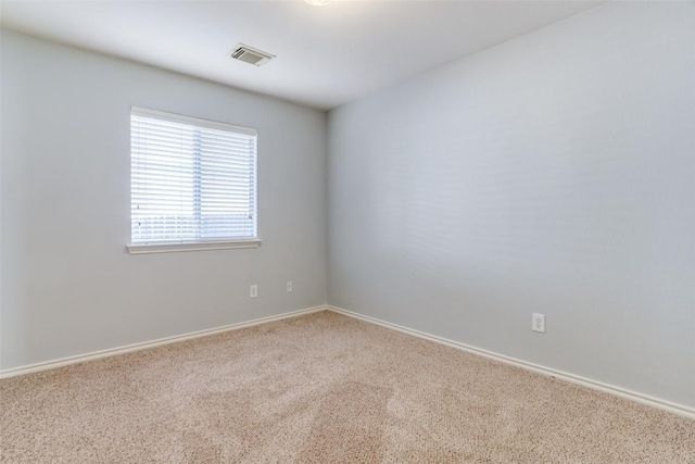 unfurnished room with carpet flooring, baseboards, and visible vents