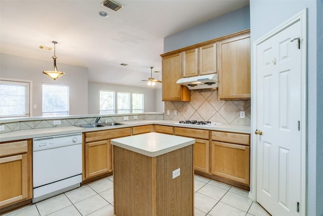 kitchen featuring backsplash, visible vents, a sink, under cabinet range hood, and white appliances