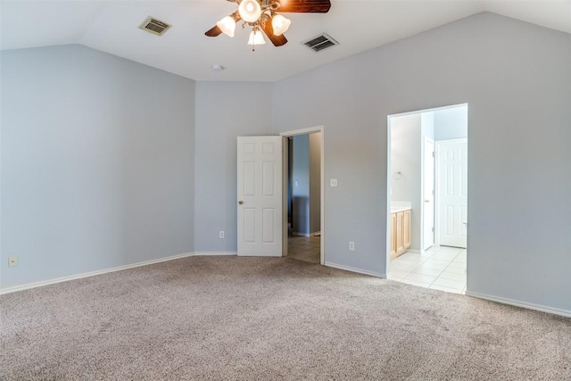 unfurnished bedroom featuring baseboards, visible vents, light carpet, and lofted ceiling
