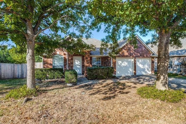 view of front of property with a garage, fence, brick siding, a shingled roof, and driveway