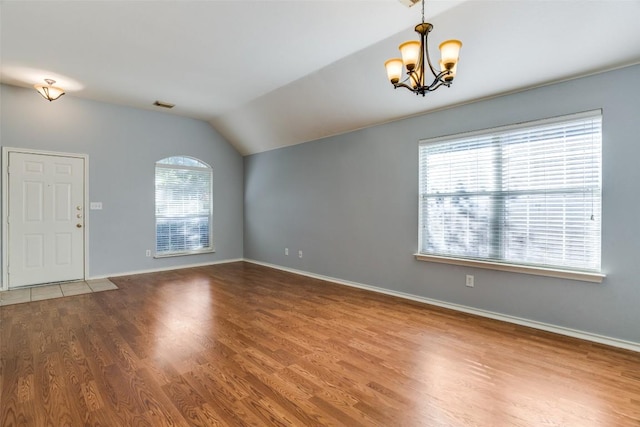 interior space featuring visible vents, a notable chandelier, a wealth of natural light, and lofted ceiling