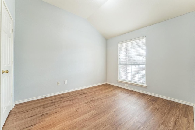 7418 W Magic Mountain Ln, Round Rock, TX 78681 - spare room with vaulted ceiling, baseboards, and light wood-type flooring