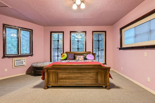 bedroom featuring a textured ceiling, light colored carpet, and a wall mounted AC