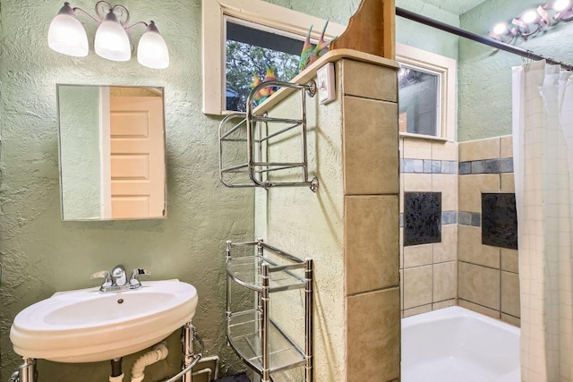 bathroom featuring a sink and a textured wall