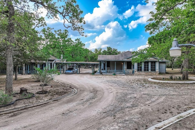 view of front facade featuring a porch, a carport, and driveway