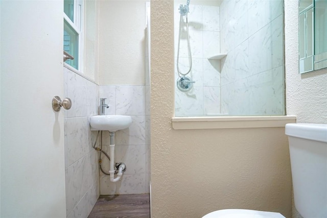 bathroom with a textured wall, wood finished floors, and toilet