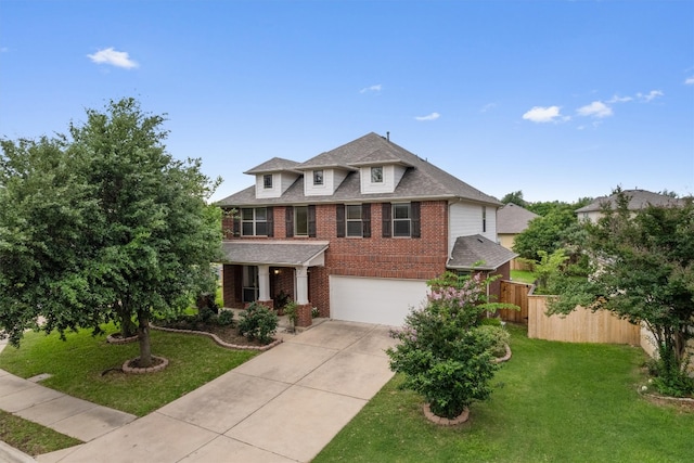 traditional-style house featuring fence, a front yard, brick siding, an attached garage, and driveway