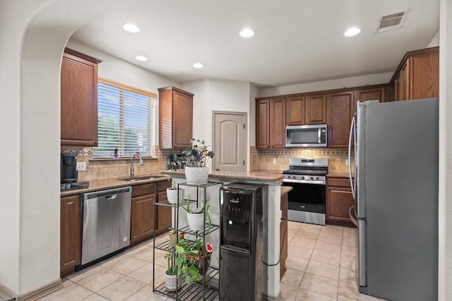 kitchen featuring visible vents, appliances with stainless steel finishes, tasteful backsplash, a sink, and light tile patterned flooring