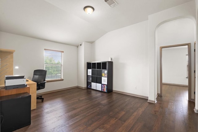office space with baseboards, visible vents, vaulted ceiling, and dark wood-type flooring