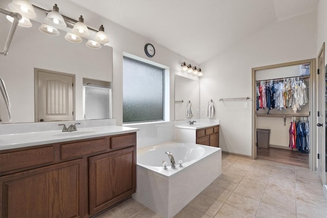 bathroom with a sink, a shower stall, two vanities, vaulted ceiling, and a bath