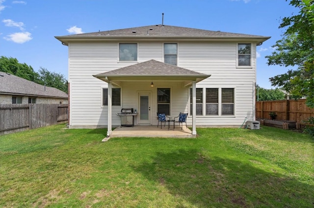 rear view of house with a lawn, a patio, and a fenced backyard