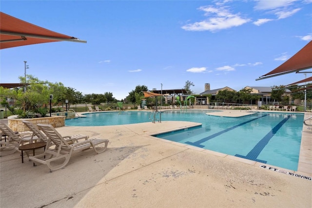 community pool with a patio and fence