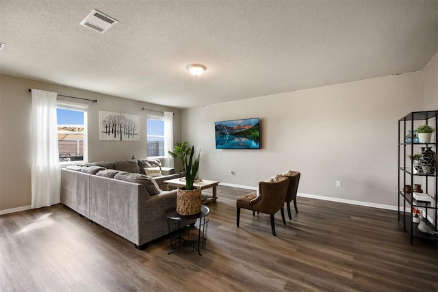 living area featuring visible vents, baseboards, and dark wood-style floors
