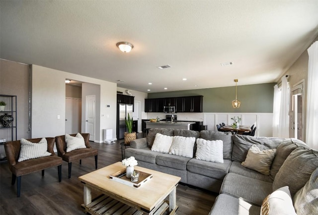 living area featuring visible vents and dark wood-style flooring