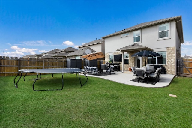 217 Frederick Dr, Georgetown, TX 78626 - rear view of house with a patio area, stucco siding, brick siding, and a trampoline